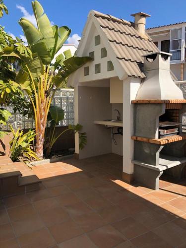 a backyard with a outdoor kitchen and a house at Casa con piscina ideal vacaciones en la playa in Comarruga