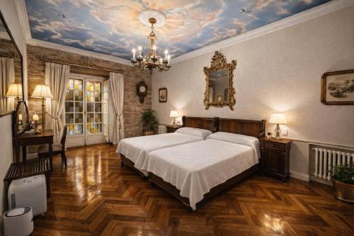 a bedroom with a bed and a painting of clouds on the ceiling at Palacio Pampinot in Hondarribia