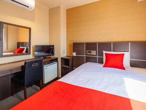 a bedroom with a bed and a desk with a red pillow at My Hotel Okazaki - Vacation STAY 40782v in Okazaki