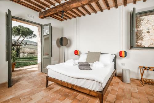 a bedroom with a white bed and a glass door at Salcheto WineHouse in Montepulciano