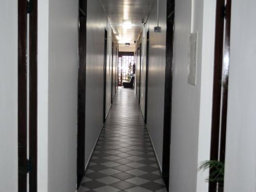 a hallway in a building with black and white tiles at Hotel Enseada de Ponta Negra in Natal