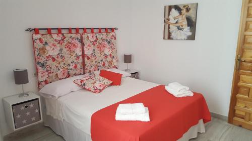 een slaapkamer met een bed met een rood-witte deken bij Casa Típica Cordobesa in Córdoba