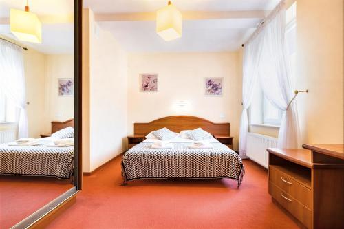 a bedroom with two beds and a large mirror at IK Apartamenty in Rzeszów