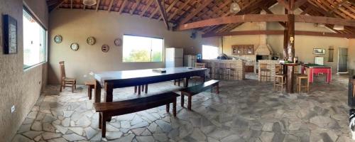 a large room with a dining table and a kitchen at Recanto do Joao Sta Isabel in Santa Isabel