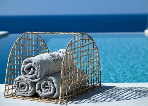 a basket filled with towels next to a swimming pool at Arpathea Villas in Foinikion