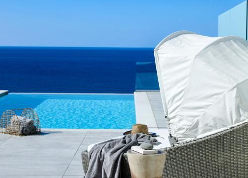 a teddy bear sitting in a chair next to a pool at Arpathea Villas in Foinikion