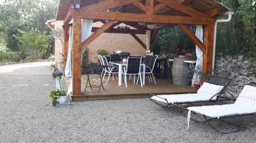 a pavilion with chairs and a table and a grill at L'Abrialys in Lorgues