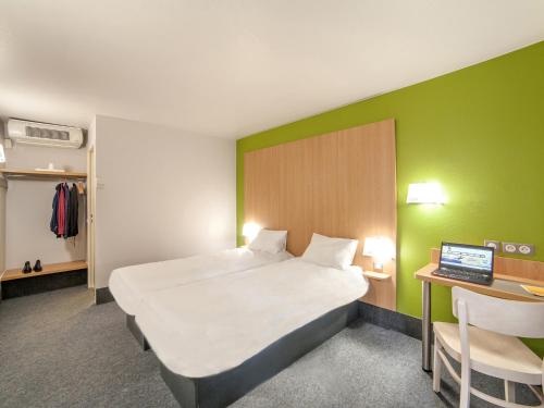 Un pat sau paturi într-o cameră la B&B HOTEL Herblay