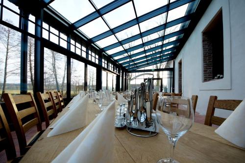 a long table with wine glasses in a room with windows at Hotel Wasserschloss Mellenthin in Mellenthin
