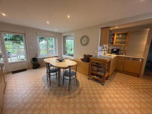 a kitchen with a table and chairs in a room at Demeure Saint Gildas in La Haye-Pesnel