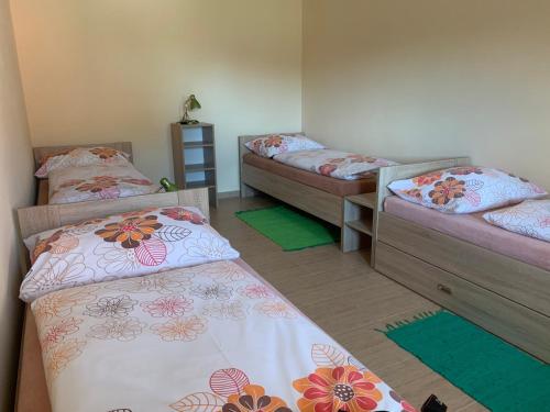 three beds in a room with mats on the floor at Apartmány Vinařství Tesařík in Prušánky