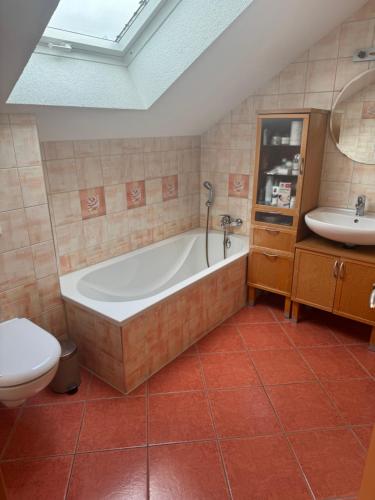 a bathroom with a tub and a toilet and a sink at Ferienzimmer Schürer in Lauter