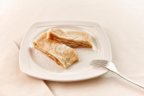 a plate with two pieces of bread on it with a fork at Hotel Mrak in Ljubljana