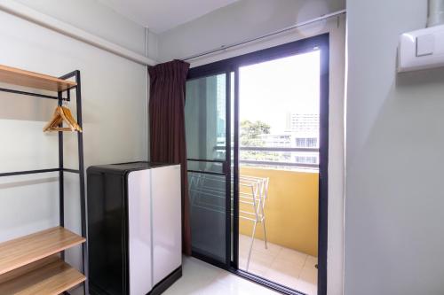 a black refrigerator in a room with a balcony at Annex Lumpini Bangkok in Bangkok