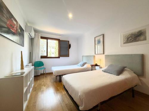 a hotel room with two beds and a window at Villa Palma 3 in Palma de Mallorca