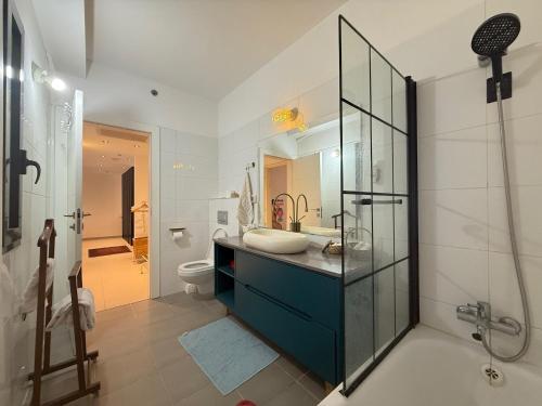 a bathroom with a sink and a shower and a toilet at שלוות העמק - דירת 3 חדרי שינה במיקום מרכזי in Ganne Tiqwa