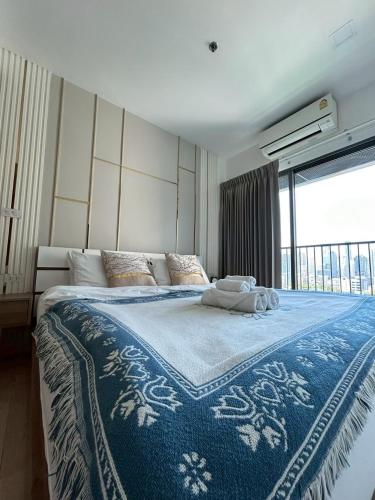 a bedroom with a large bed with a blue and white blanket at Luxury Condo Skywalk BTS Thonglor Pool Gym and Netflix in Bangkok