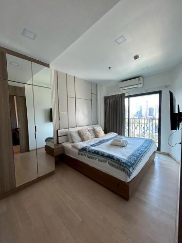 a bedroom with a large bed and a large window at Luxury Condo Skywalk BTS Thonglor Pool Gym and Netflix in Bangkok