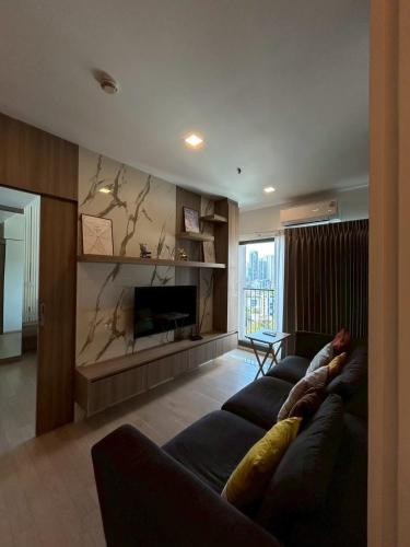 a living room with a couch and a fireplace at Luxury Condo Skywalk BTS Thonglor Pool Gym and Netflix in Bangkok