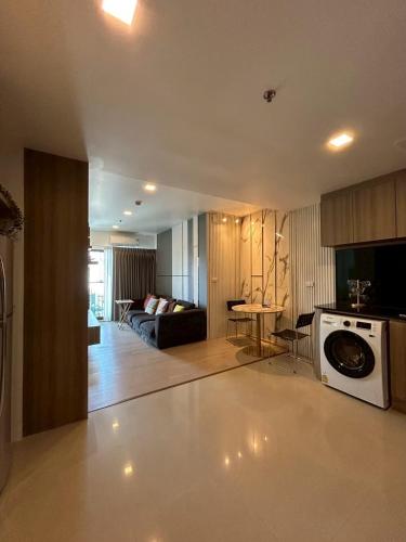 a living room with a couch and a washing machine at Luxury Condo Skywalk BTS Thonglor Pool Gym and Netflix in Bangkok