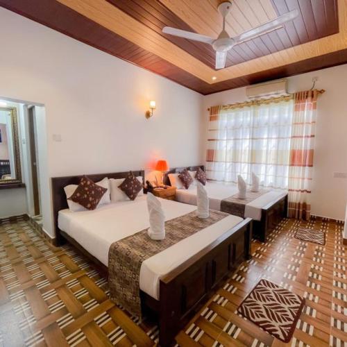 a bedroom with two beds and a couch at Yaalu-Yaalu in Welikanda