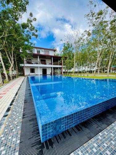a large blue swimming pool in front of a building at Yaalu-Yaalu in Welikanda