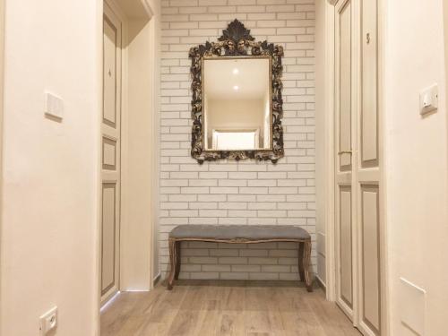 a mirror on a wall with a bench in a hallway at Maglo Centro in Bologna