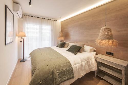 a bedroom with a large bed and a wooden wall at The Miks Sur Mer 2 in Roses