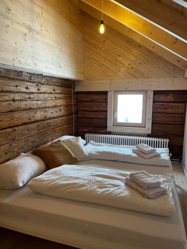 a large bed in a room with wooden walls at Hirschberg 231 in Bizau
