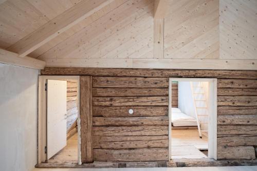 a room with a wooden wall with a doorway at Hirschberg 231 in Bizau