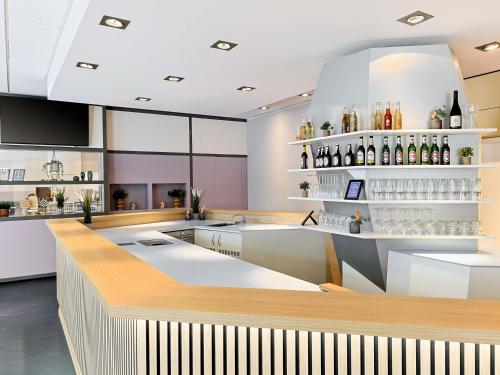 a bar in a restaurant with bottles on the shelves at B&B Hotel Bremen-Altstadt in Bremen