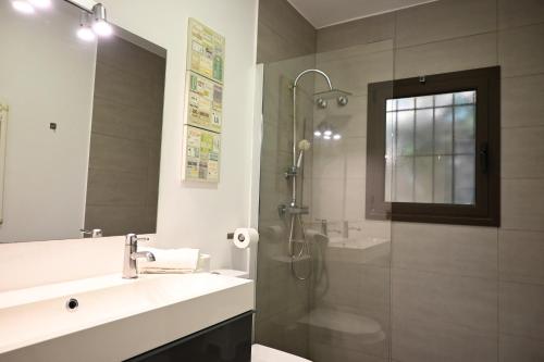 a bathroom with a shower and a sink and a mirror at Homenfun Costa Brava Begur Villa in Begur