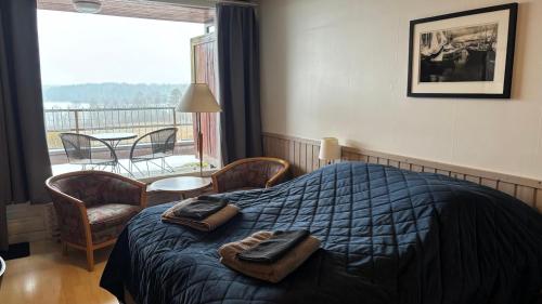 a bedroom with a bed with two towels on it at Hotelli Kantakievari in Ruovesi