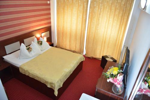 a hotel room with a bed and a television at Hotel Valahia in Târgovişte