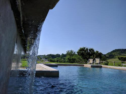 a water fountain in the middle of a pool at Wild Agriturismo Podere della Bruciata in Chiusi