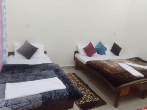 a room with two beds and a table with pillows at Hotel Kalyan Palace And Restaurant in Pīpalkoti
