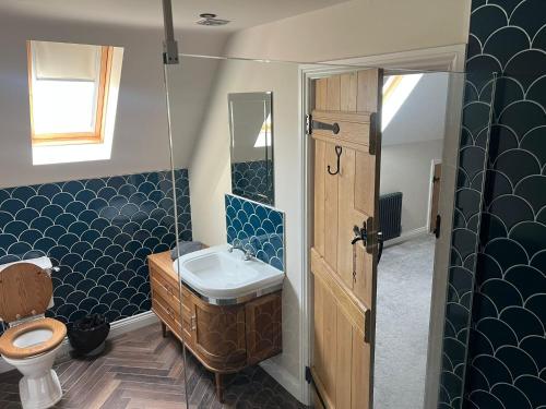 a bathroom with a sink and a toilet at Fallow View - Luxury Countryside Cottage in Coughton