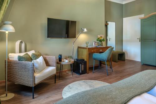 a living room with a couch chair and a table at Hotel Würzburger Hof **** in Würzburg