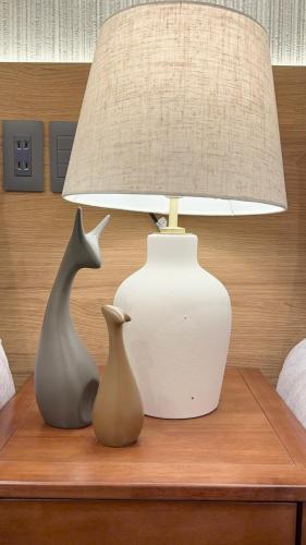 two vases sitting on a table next to a lamp at AKATSUKI HOTEL Ueno JR山手線鶯谷駅まで徒歩3分 成田空港直行 新宿渋谷直通 in Tokyo