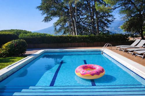 a swimming pool with a donut on a float in the water at Cabril's Hills - Stunning Villa with Pool & Sea Views in Cabrils