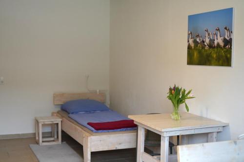 a bedroom with a bed and a table and a painting at Haus Gänsefarm - Ihre Monteurs Wohnung - in Husby