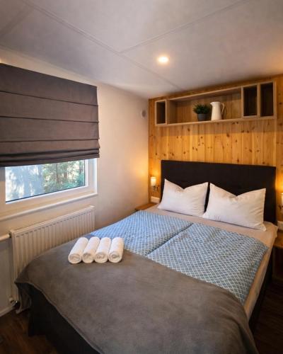 a bedroom with a bed with two slippers on it at NATURAMA Brombachsee Tinyhaushotel in Pleinfeld