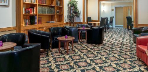 a waiting room with chairs and tables in a library at Carrington House Hotel in Bournemouth