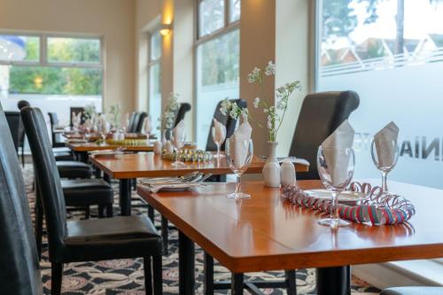 a row of wooden tables with wine glasses on them at Carrington House Hotel in Bournemouth