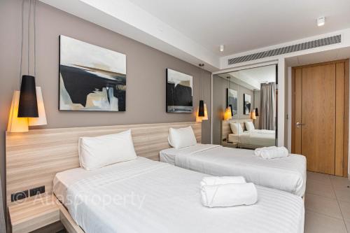 a bedroom with two beds in a hotel room at Oceanstone- 2BDR apartment in Ban Thalat Choeng Thale