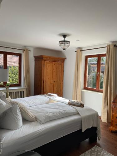a bedroom with a large bed and two windows at Gästehaus Sandvoss in Titisee-Neustadt
