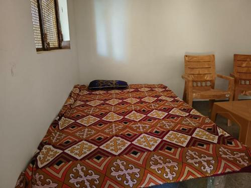 a bed in a room with a quilt on it at Virendra Home Stay in Kartal