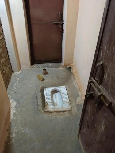 a dirty bathroom with a toilet in a room at Virendra Home Stay in Kartal