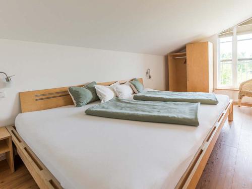 two large white beds in a room at Ferienhof Rummel Allgäu - verschiedene Unterkünfte für bis zu 6 Personen - Sauna, Spielplatz, Lagerfeuer & Frühstücksservice - ideal für Familien- und Aktivurlaub in Argenbühl