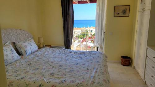 a bedroom with a bed and a view of the ocean at Pasha Bay Residence in Sounio
